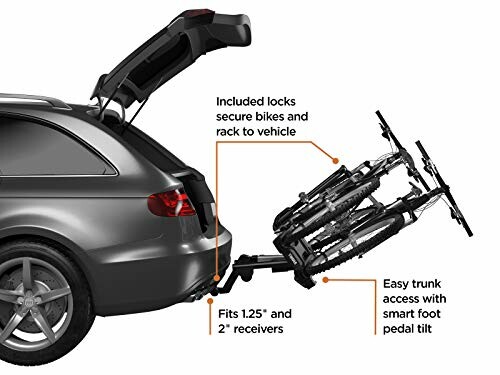 Car with rear bike rack holding two bicycles, trunk open.