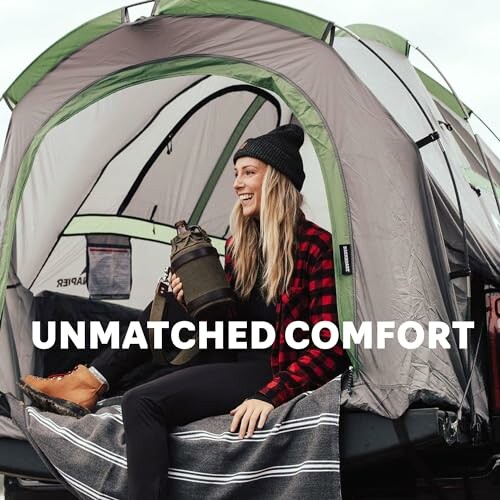 Woman smiling in tent with camping gear